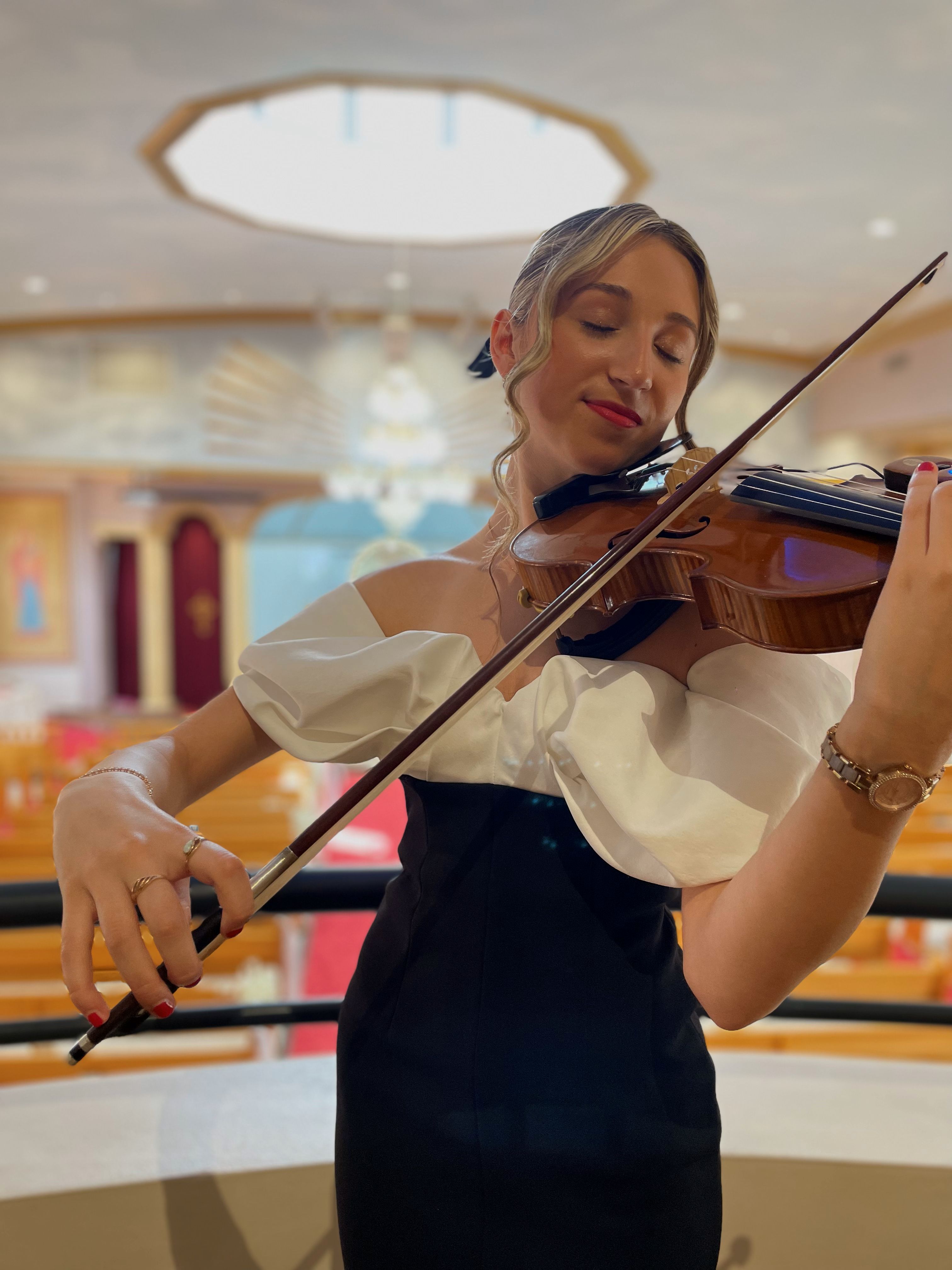 Tali playing violin in concert hall